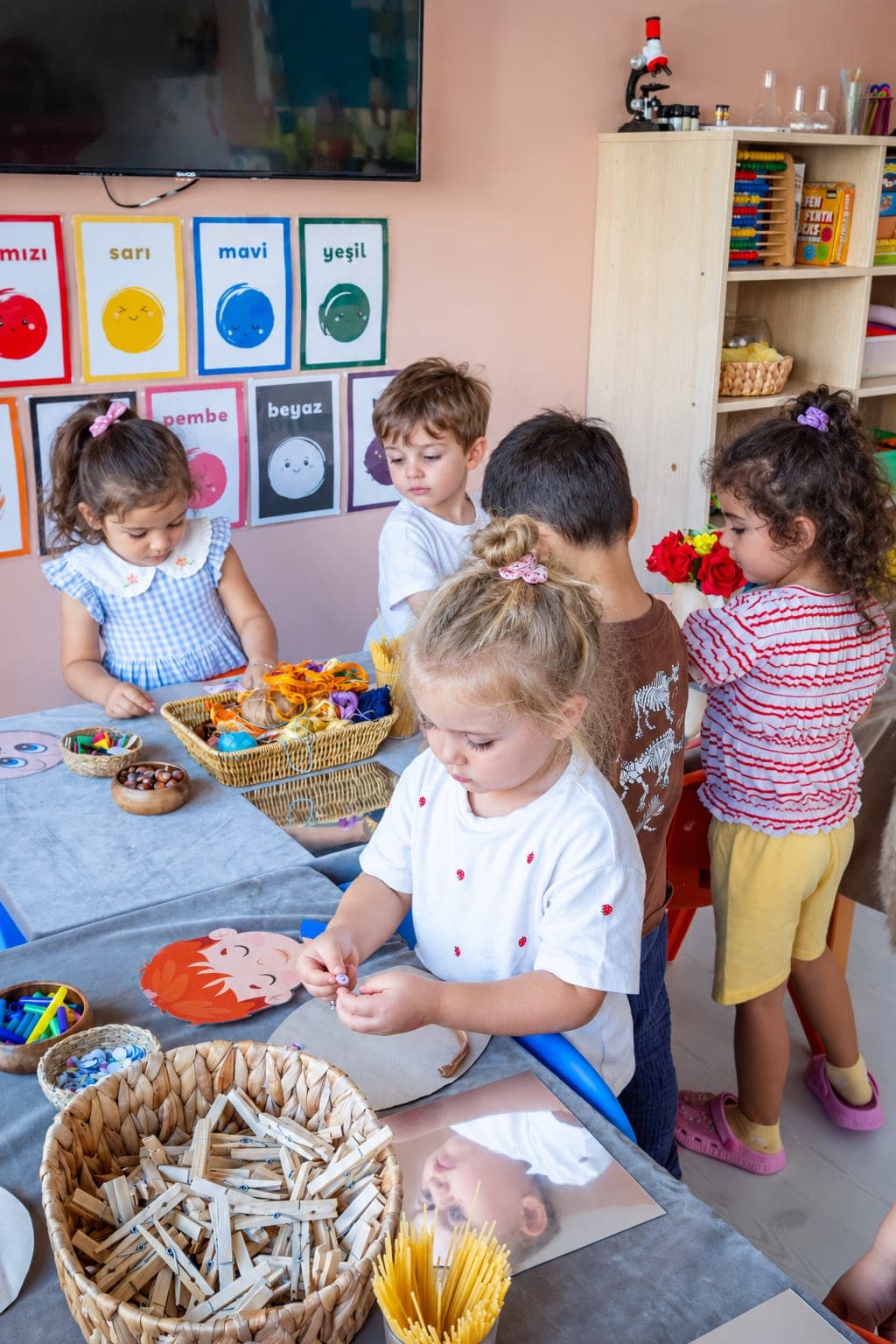 Meyve sepetinin başında birlikte çalışan üç çocuk